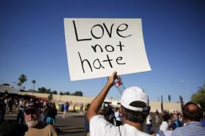 A demonstrator holds a sign at a "Freedom of Speech Rally Round II" across the street from the Islamic Community Center in Phoenix, Arizona May 29, 2015.  Arizona police stepped up security near a mosque on Friday ahead of a planned anti-Islam demonstration featuring displays of cartoons of the Prophet Mohammad, weeks after a similar contest in Texas came under attack from two gunmen.  REUTERS/Nancy Wiechec